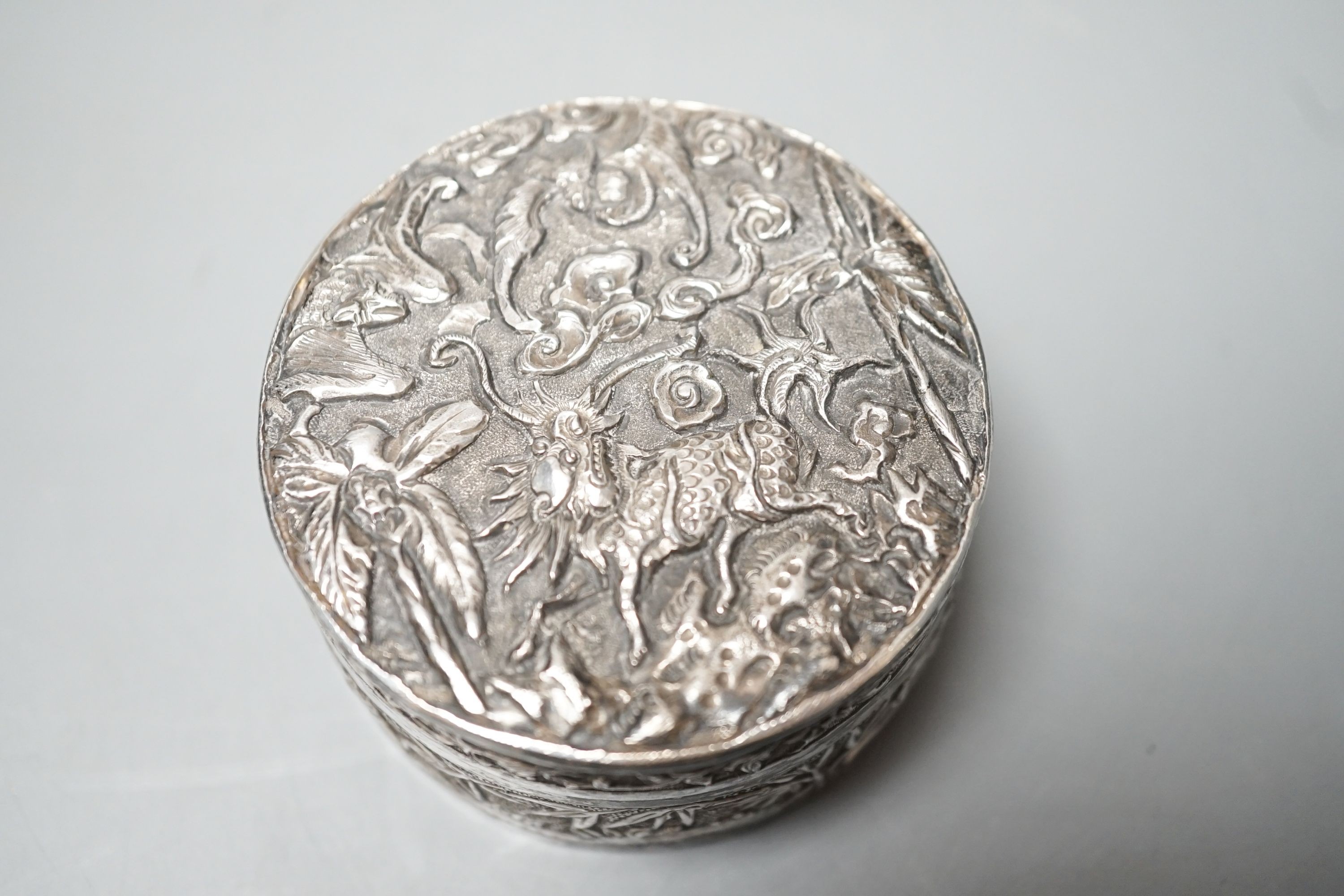 A Chinese embossed white metal circular box and cover, late 19th century, diameter 61mm.